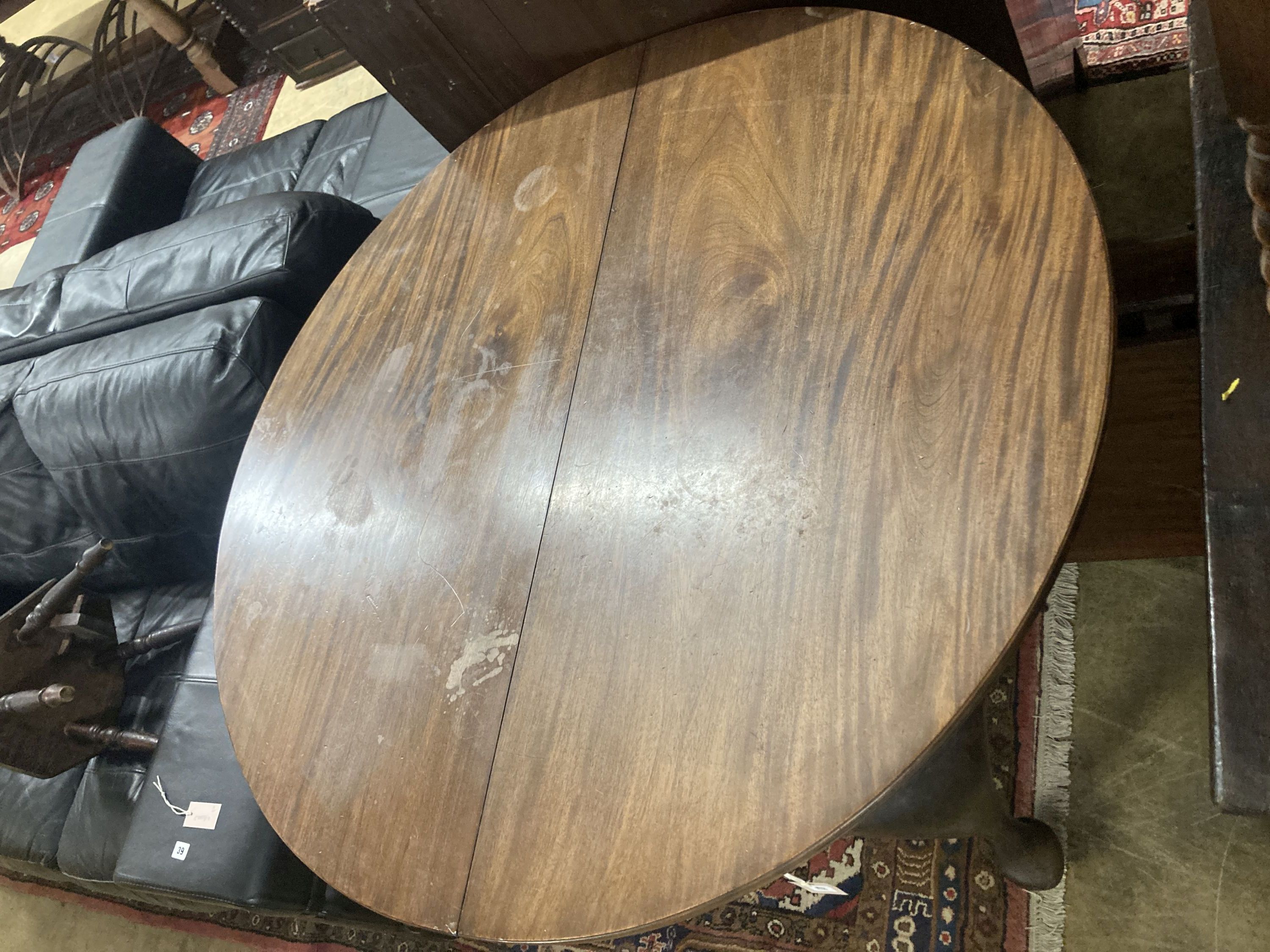 A 1920's circular mahogany extending dining table with three leaves and handle, length approx. 230cm extended, width 120cm, height 75cm